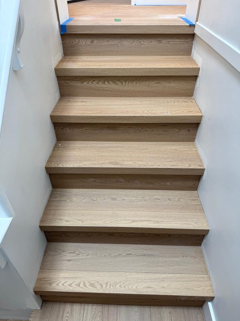 Luxury vinyl plank floor and matching stair cladding installed by Craftbuild in New Westminster